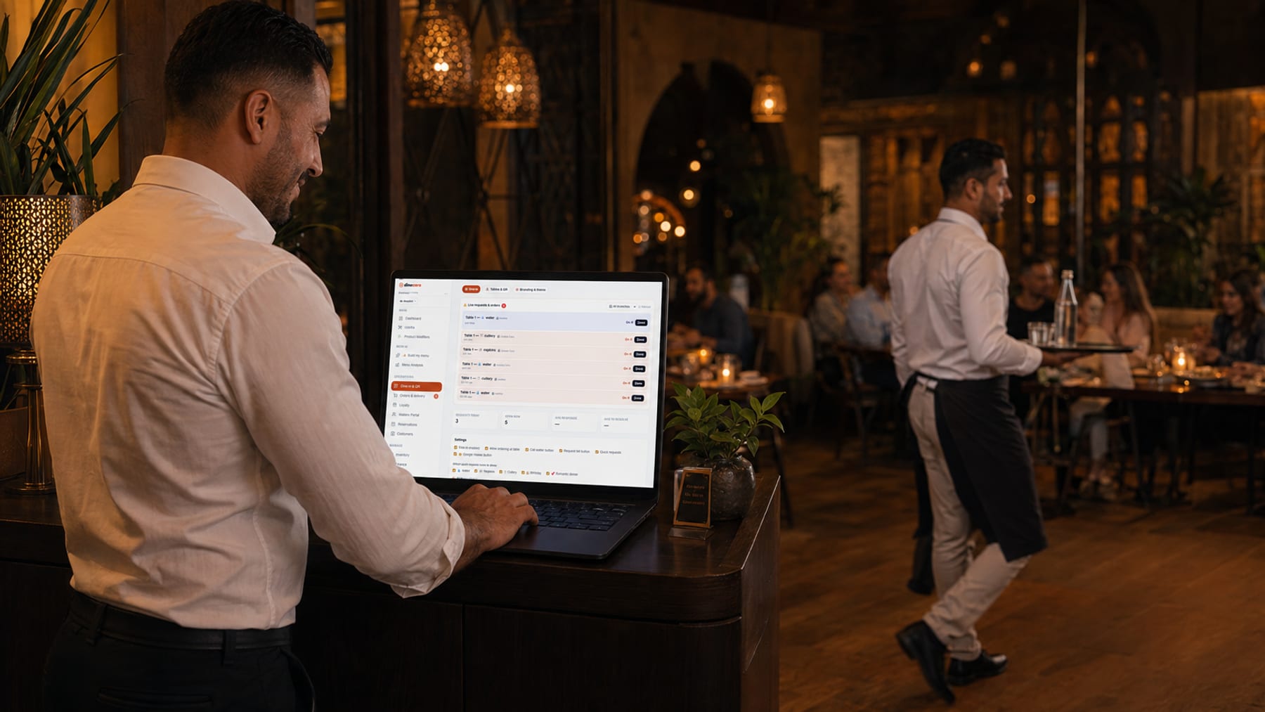 An owner reviews live table requests and orders on the DineCore dashboard while a waiter serves the floor